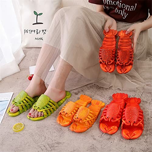 Person holding and wearing lobster-shaped slippers in green and orange.