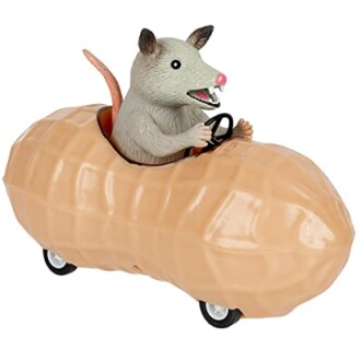 A toy possum driving a peanut-shaped car.