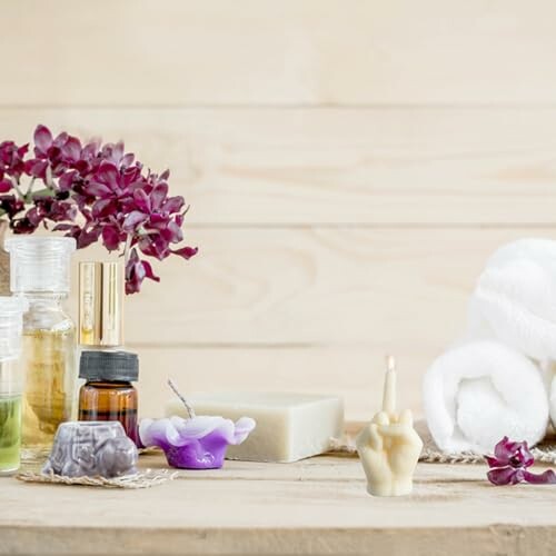 Spa essentials including oils, soap, candles, and flowers on a wooden table.